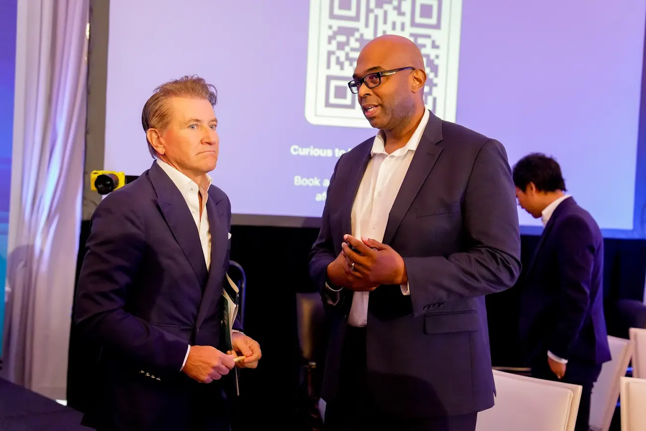 Robert Herjavec standing on stage talking with a founder after their pitch