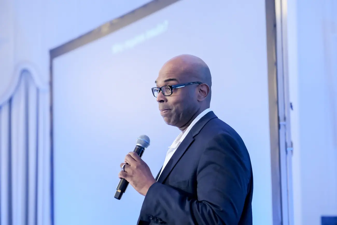 A founder answering with the microphone in front of the screen